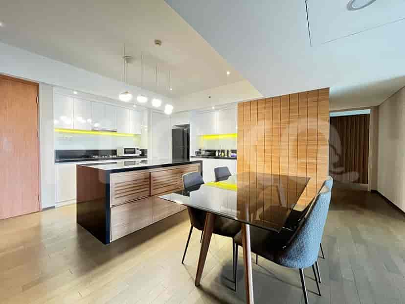 Modern kitchen with an island, dining table, and overhead lighting.
