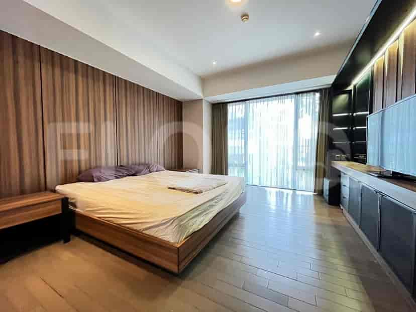 Master bedroom with a large bed, wooden paneling, and a large window.