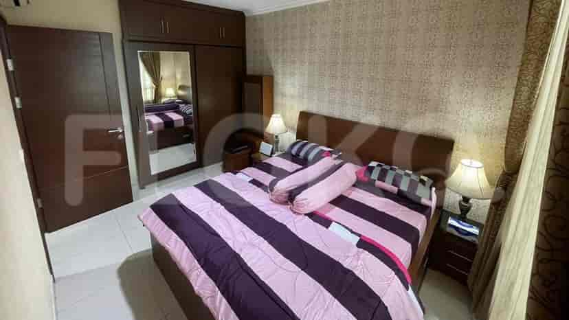 A bedroom with a bed, mirror, and wardrobe.