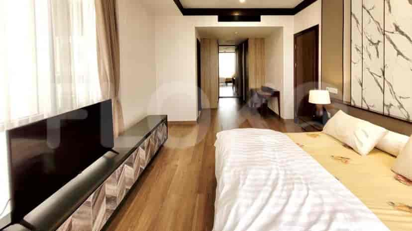 Bedroom with a TV console and a hallway.