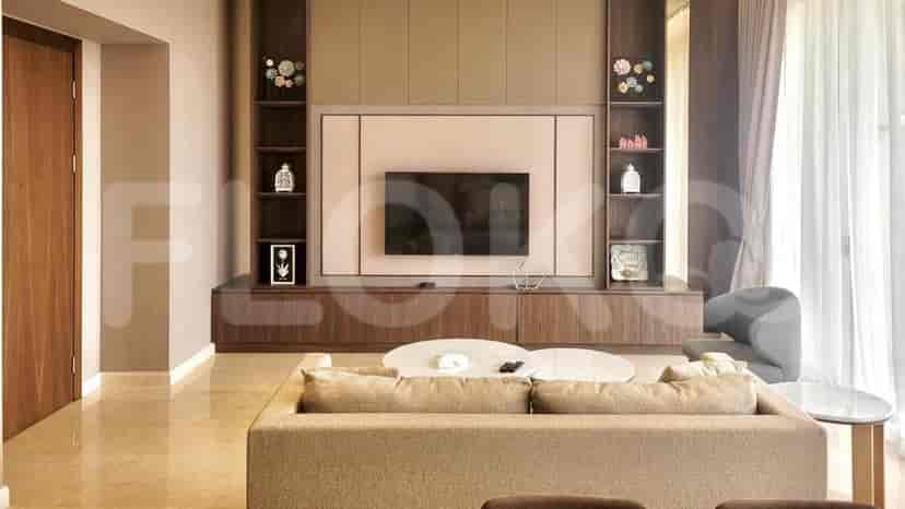 Living room with a wall-mounted TV, entertainment center, and round coffee tables.