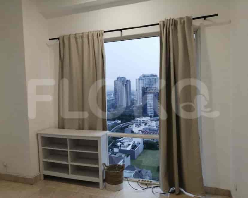 A bedroom with a large window offering a city view.