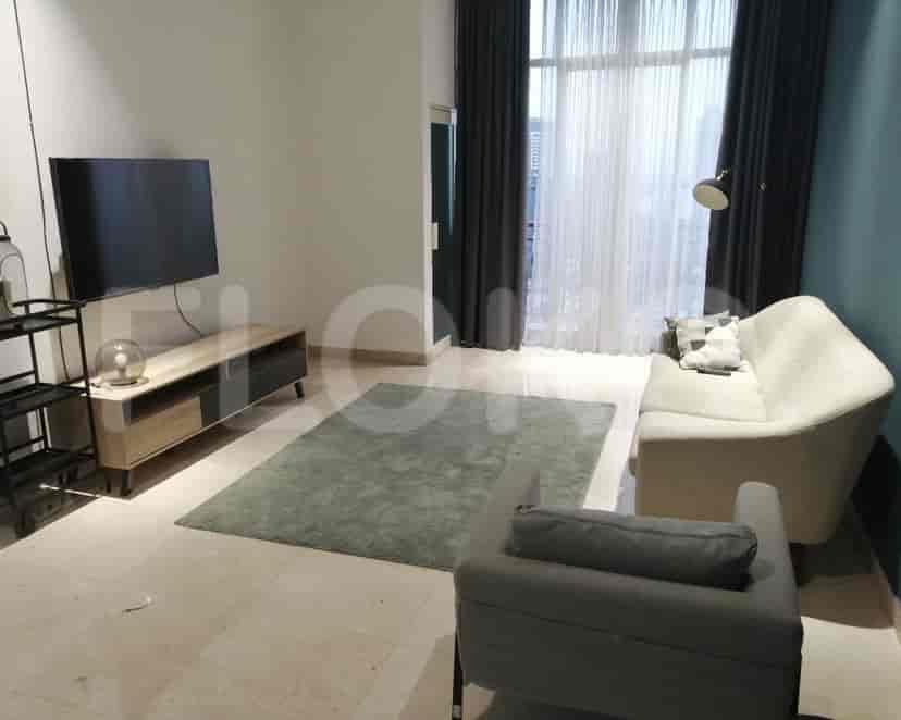 Spacious living room with a modern aesthetic, featuring a TV, sofa, and large window with curtains.