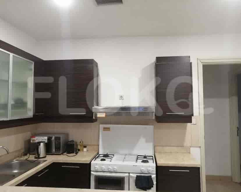 A functional kitchen with dark wood cabinets, appliances and a gas stove.