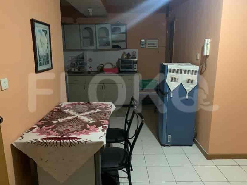 A combined kitchen and dining space with a table, chairs, and kitchen appliances.