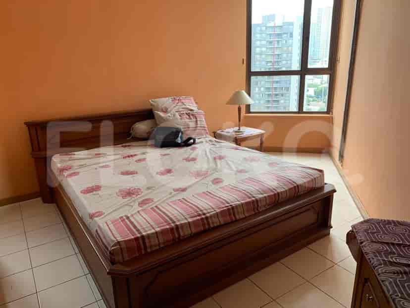 A bedroom featuring a bed, side table, and a window.