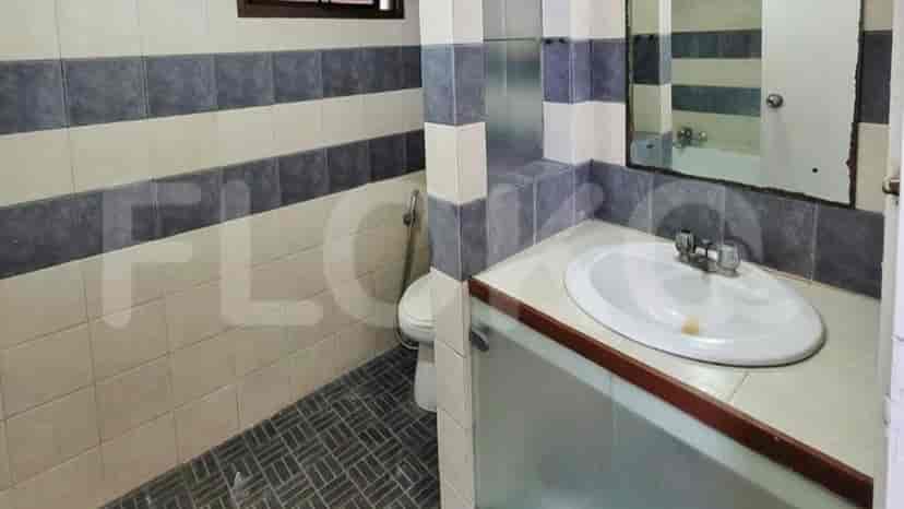 A bathroom with a sink, toilet, and tiled walls.