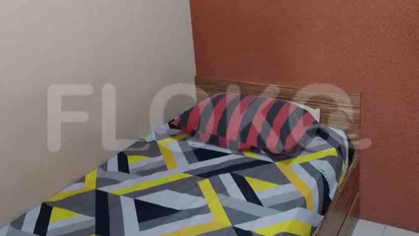 Kamar tidur dengan tempat tidur single dan seprai berwarna-warni.