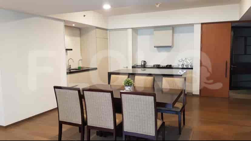 A modern kitchen with an island and dining set. The kitchen is open-plan