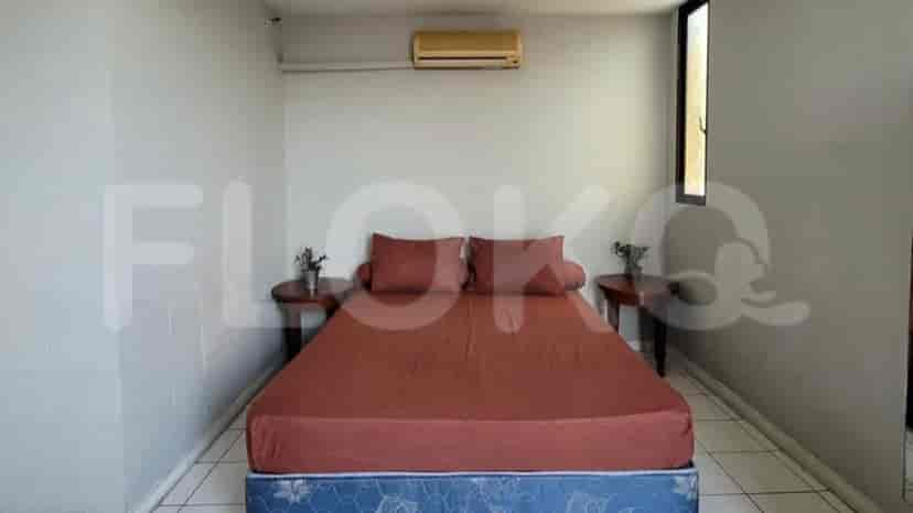 A bedroom with a bed, bedside tables, and an AC unit.