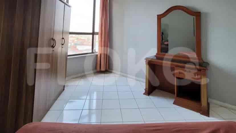 A bedroom with a wardrobe, dressing table with mirror, and a window with curtains.