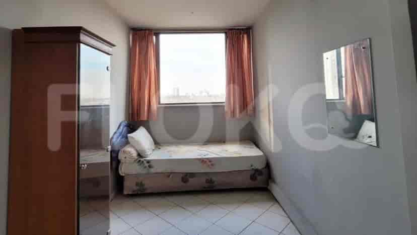 A small bedroom with a bed and a wardrobe with mirror doors.