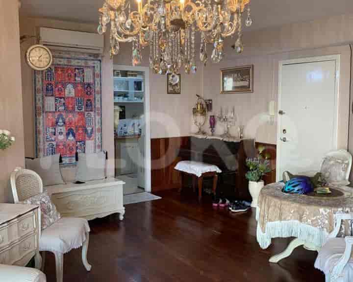 An ornate living room featuring a chandelier, antique furniture, and a Persian rug.