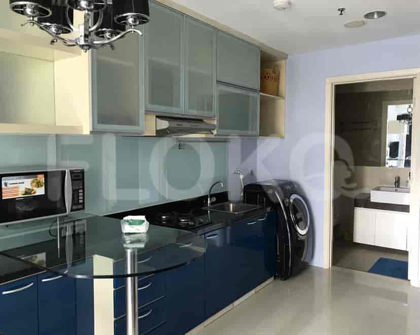 Dapur bergaya dengan lemari biru, meja kaca, dan oven built-in.