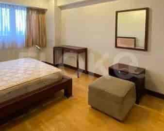 Bedroom featuring a bed, wooden floor, and a window with curtains.