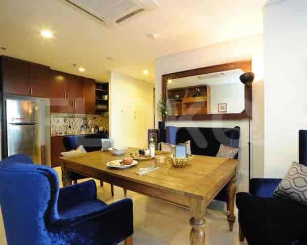 A dining area with a wooden table, blue chairs, and a mirror.