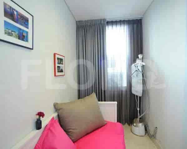 A small room with a sofa, curtain, and framed art.