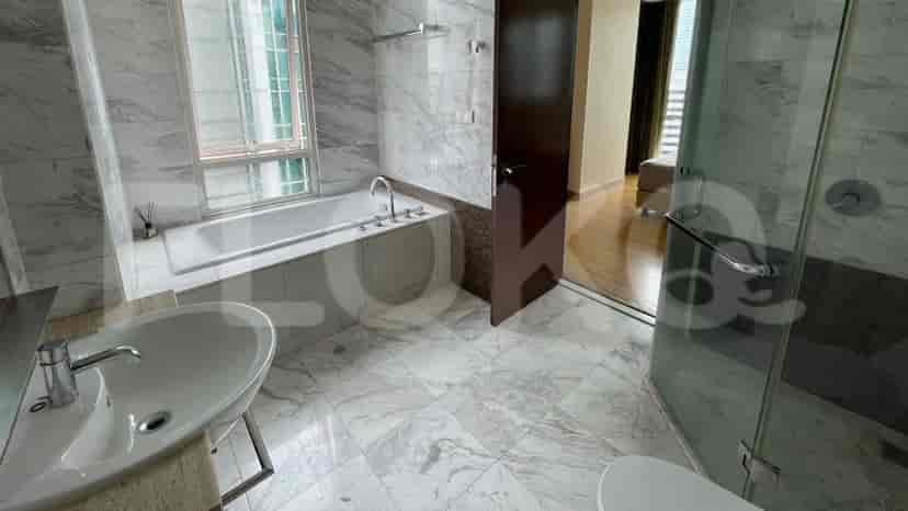 A luxurious bathroom with a bathtub, a glass shower, and marble flooring.