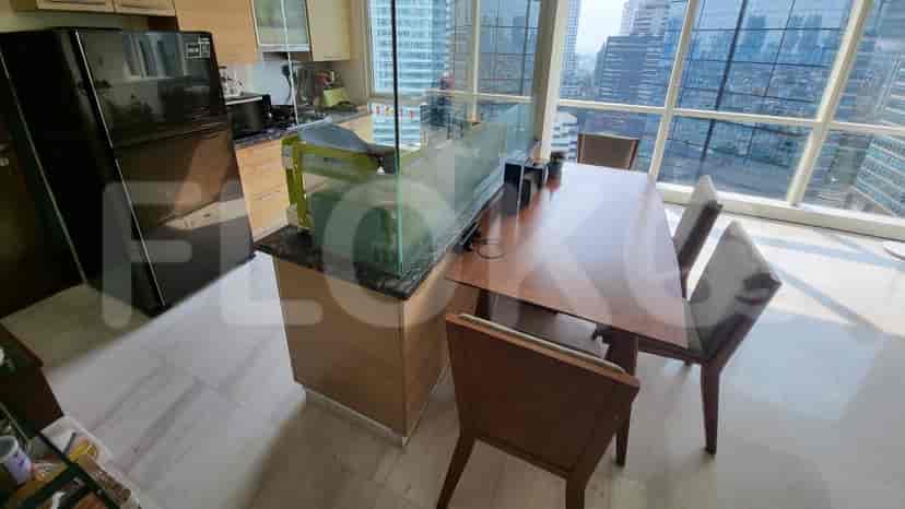 Modern kitchen with a dining table and chairs next to a window with city views.