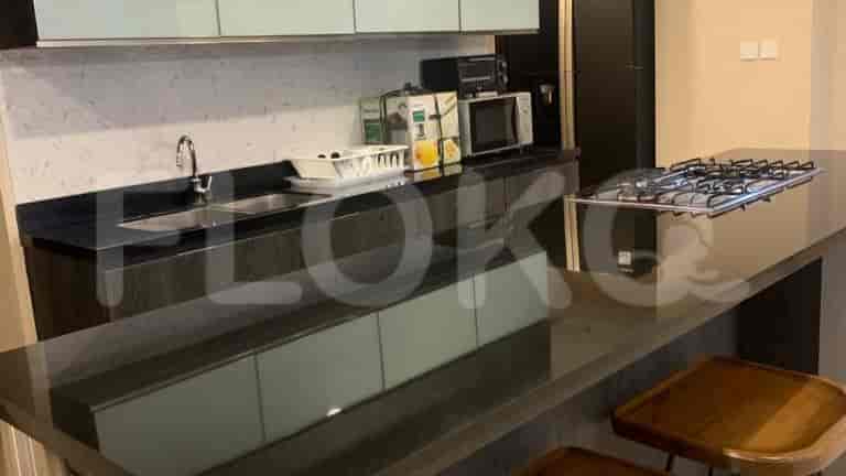 A kitchen with a black countertop and bar stools