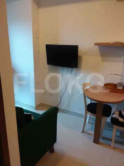 A view of the living room with a wall-mounted TV and dining table.