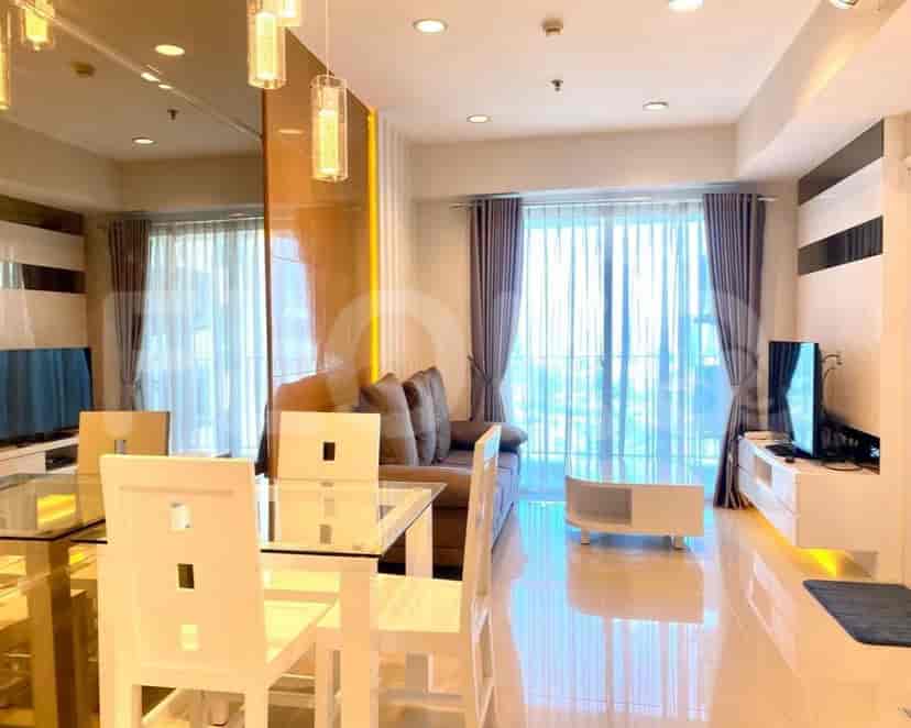 Area gabungan ruang tamu dan ruang makan, menampilkan sofa, meja makan, dan pemandangan area dapur.