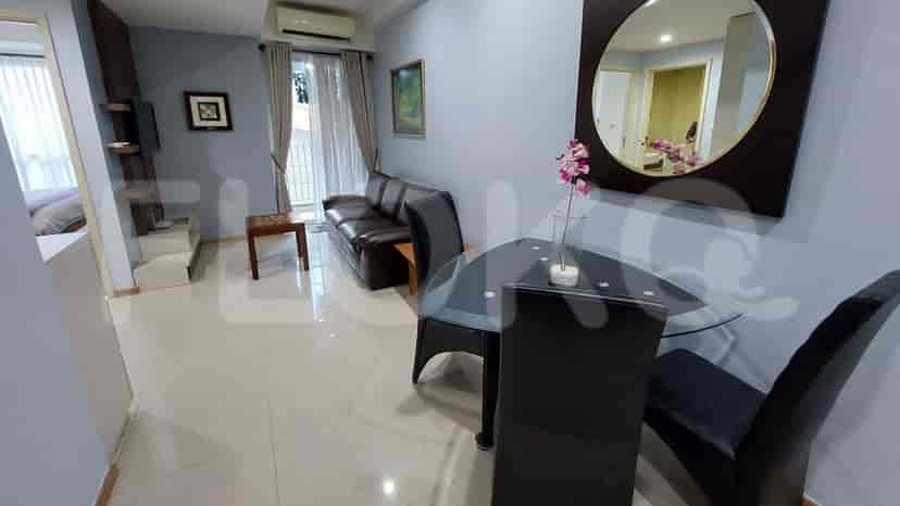 Dining area with glass table, chairs, and a mirror, showcasing a modern apartment.