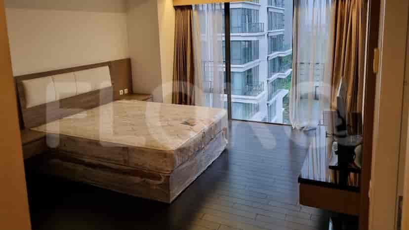 Bedroom with a bed, large windows with curtains, and a TV stand.