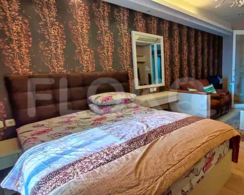 A bedroom with a bed, a patterned wall, and a vanity.