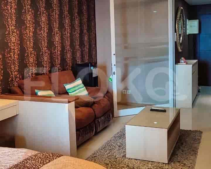 Living room with a brown sofa, a coffee table, and a patterned wall.