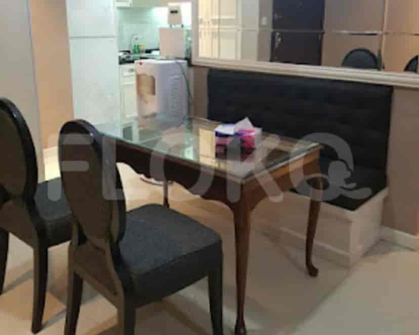 Dining area with a glass-topped wooden table, black chairs, and a built-in bench.