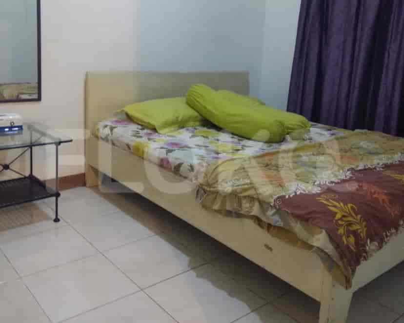 Kamar tidur dengan tempat tidur, cermin, dan meja samping tempat tidur.
