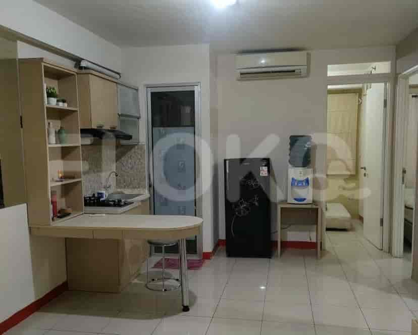 Dapur ringkas dengan area makan built-in, menampilkan lemari kayu dan kompor.