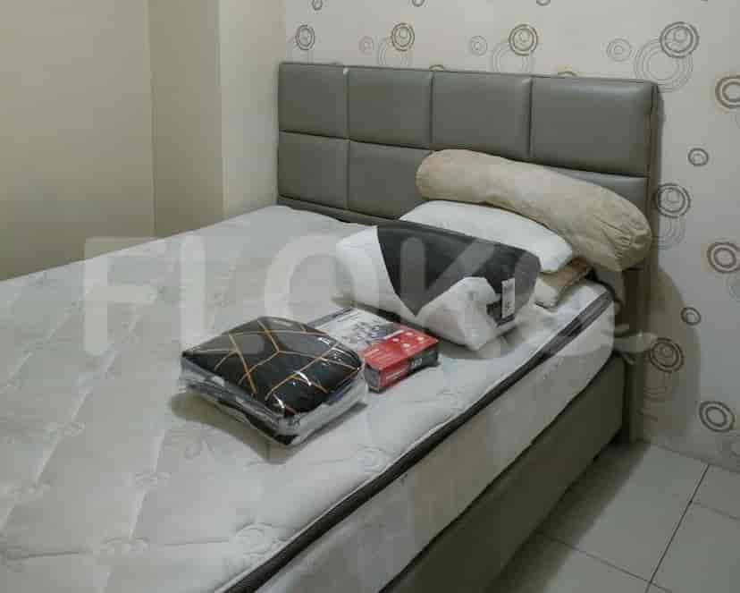Kamar tidur dengan tempat tidur yang ditutupi sprei.