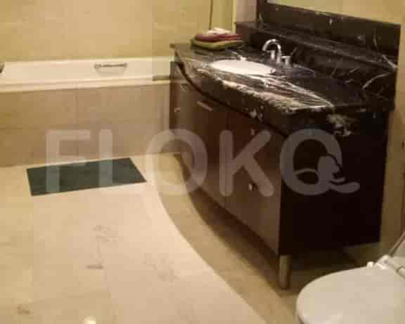 A bathroom with a white bathtub, a marble countertop vanity, and a toilet.