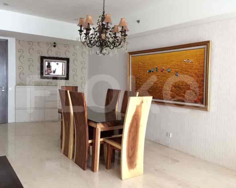 Elegant dining room with a wooden table, chairs, and chandelier.
