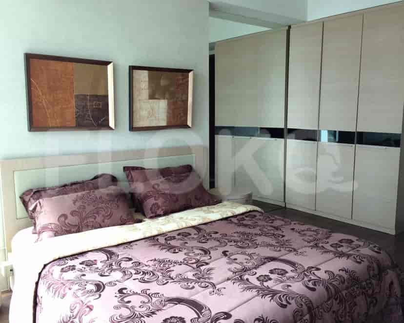A modern bedroom with a bed, artwork, and a closet.