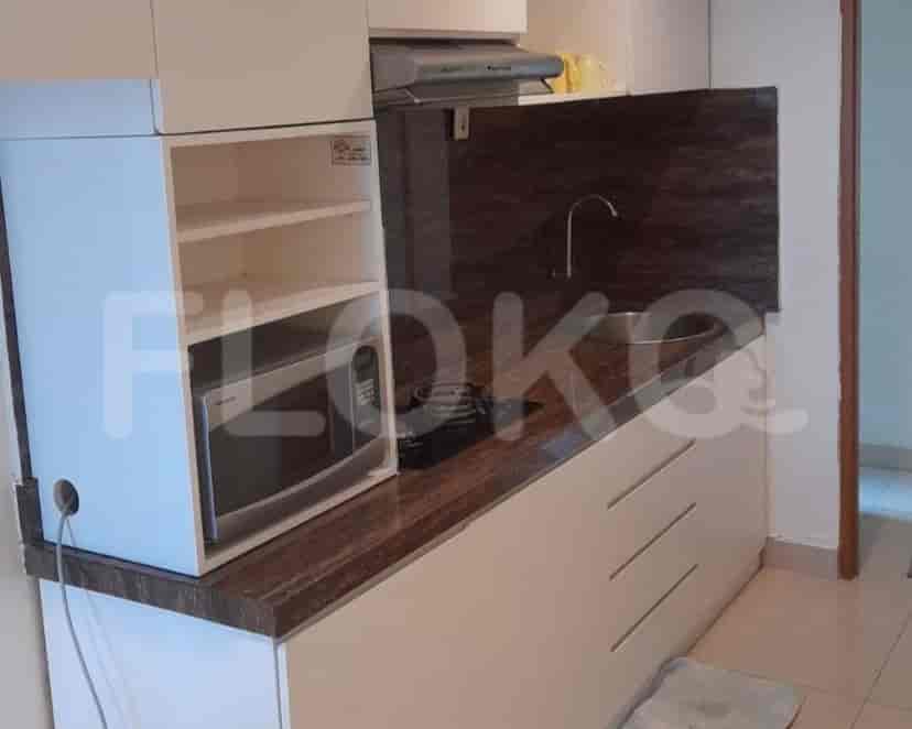 Small kitchen with cabinets, appliances including a microwave, and a sink.