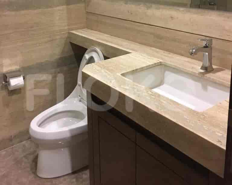 A bathroom with a toilet, sink, and counter.