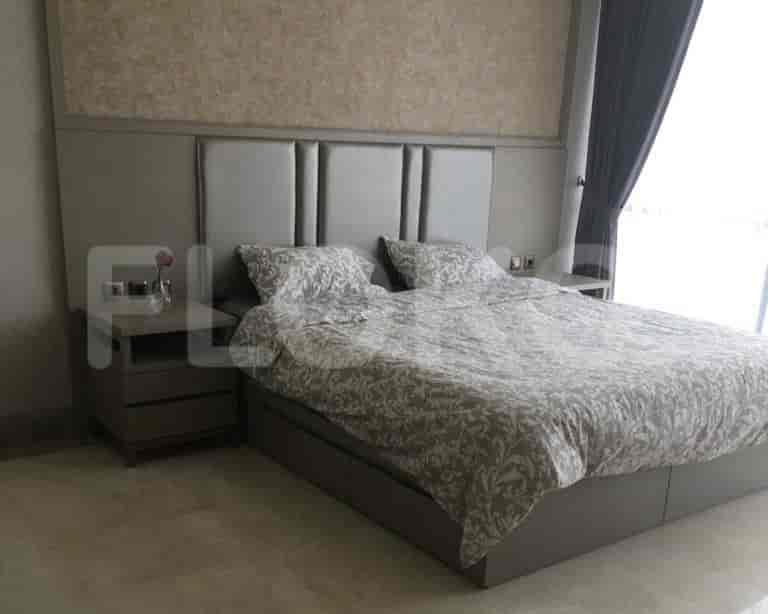 A bedroom with a bed, nightstands, and a headboard.
