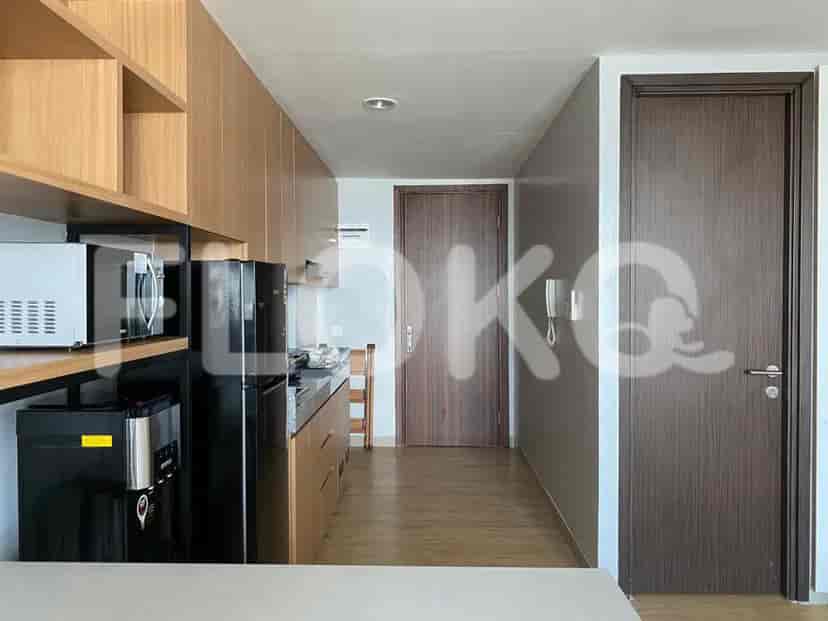 A small kitchen with a refrigerator, microwave, and cabinets.