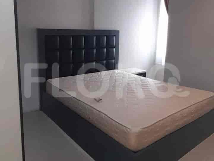 A modern bedroom with a bed and a dark headboard.