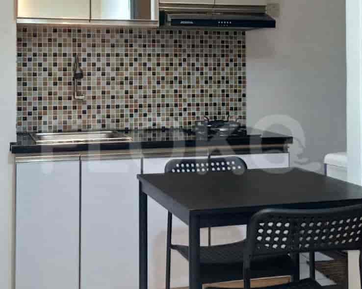 Close-up view of a kitchen with a tile backsplash, cooking range, and dining table.