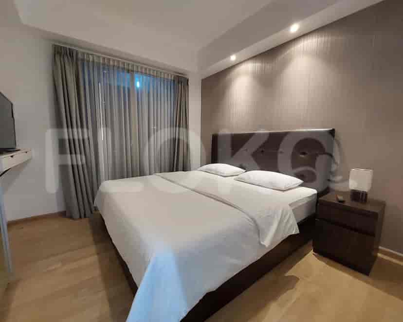A modern bedroom with a bed, curtains, and a bedside table.