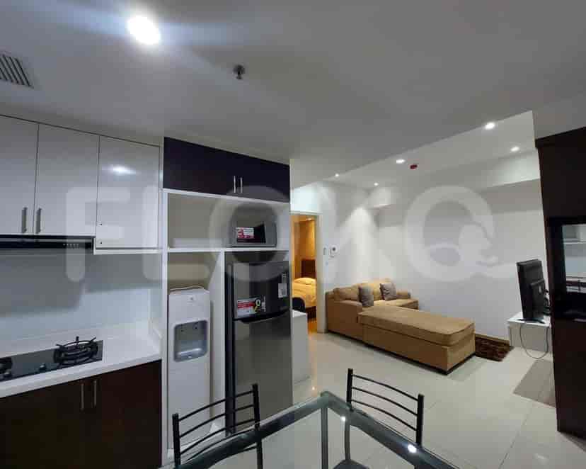 An open-plan kitchen connected to a living space with a sectional sofa.