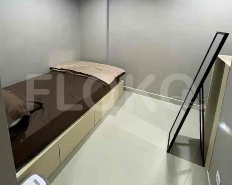 Kamar tidur kecil dengan tempat tidur dan cermin.