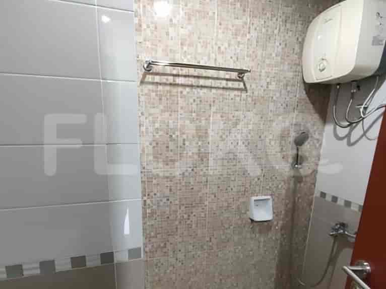 Kamar mandi yang kompak dan dirancang dengan baik menampilkan pancuran, pemanas air, dan dinding berubin.