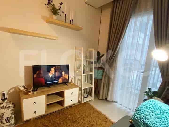 Living room with a TV, shelves, and a small entertainment area.