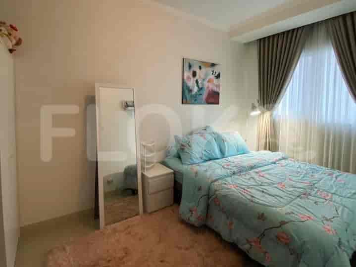 A cozy bedroom with a double bed, full-length mirror, and light-colored curtains.