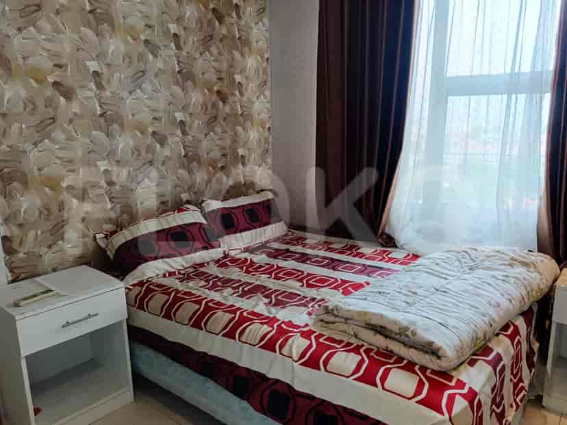 Bedroom with a bed featuring a patterned red and white bedspread.